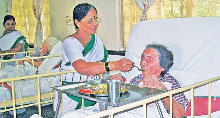 A lady helper compassionately attends to an elderly.